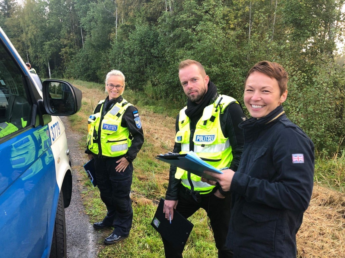 Helkurvestides politseinikud teeservas politseibussi kõrval